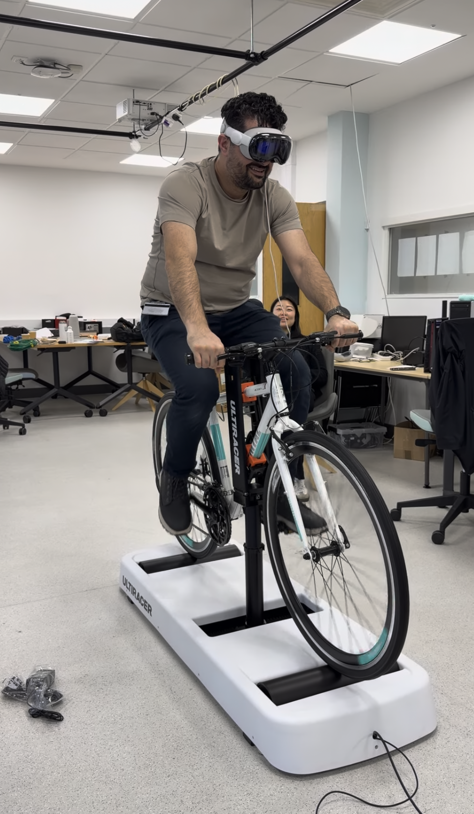 Researcher riding the Ultiracer trainer with a VR headset